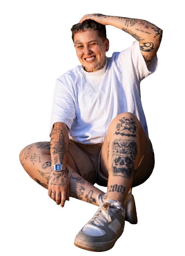 Kah Perez sentada e sorrindo, com uma mão sobre a cabeça